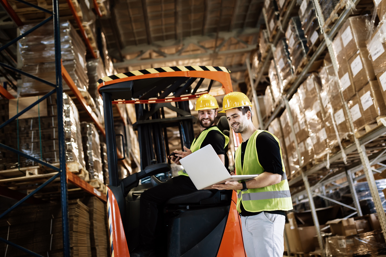Workers Using Technology And Forklift In Warehouse